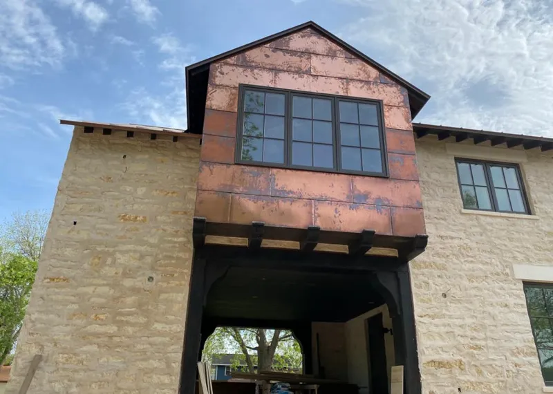 Copper metal panel facade on a stone building for Roof Repair in Vinita